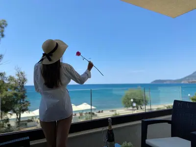 a woman in a hat is looking out at the beach at Apartments Kuce Lekovica Beach & snack bar- Bistro in Bar