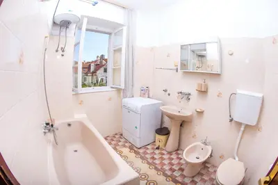 a bathroom with a tub and a toilet and a sink at Apartments Old Town in Budva