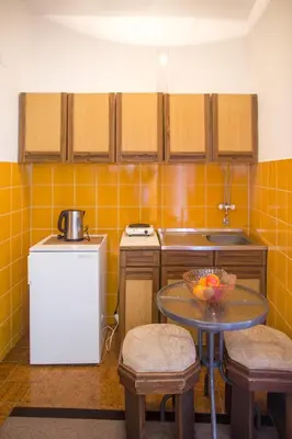 a kitchen with a table with a bowl of fruit on it at Apartments Old Town in Budva