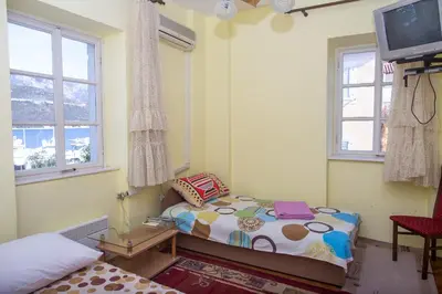 a bedroom with a bed and a tv and windows at Apartments Old Town in Budva