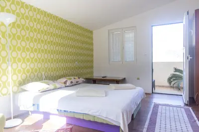 a bedroom with a large bed with a yellow wall at Apartments Old Town in Budva