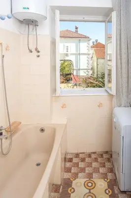 a bathroom with a tub and a window at Apartments Old Town in Budva