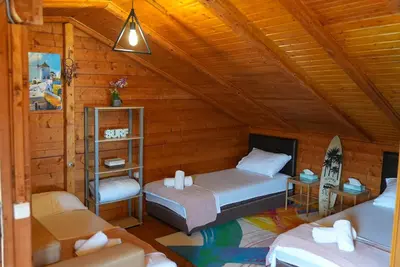 a bedroom with two beds in a wooden cabin at Ada Dream House in Kravlja