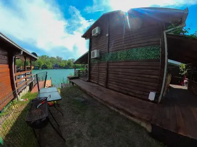 a house on a dock next to a lake at Ada Dream House in Kravlja