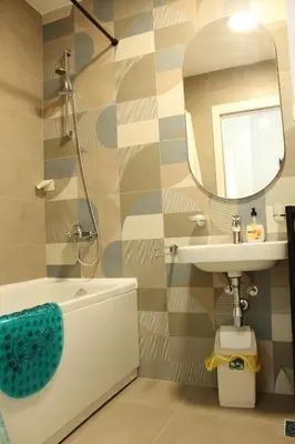 a bathroom with a tub and a sink and a mirror at Titograd in Podgorica