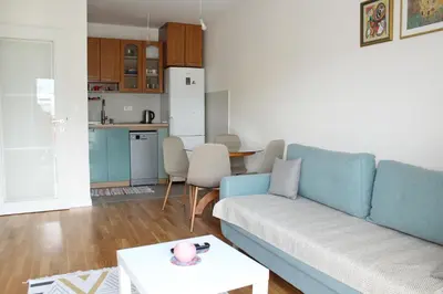 a living room with a blue couch and a kitchen at Titograd in Podgorica