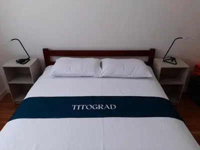 a bed in a room with two nightstands and a bed sidx sidx sidx at Titograd in Podgorica