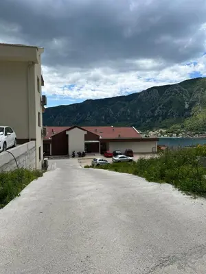 a building with cars parked on the side of a road at Maxim24 in Dobrota