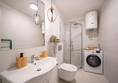 a bathroom with a sink and a washing machine at Maxim24 in Dobrota