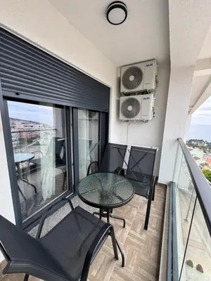 a balcony with a table and chairs and a window at Stan Pinjes - Ulcinj in Ulcinj
