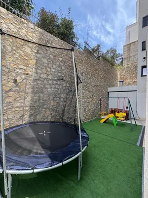 a trampoline in a yard with a stone wall at Stan Pinjes - Ulcinj in Ulcinj
