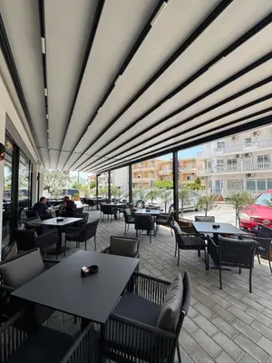 a restaurant with tables and chairs and windows at Stan Pinjes - Ulcinj in Ulcinj