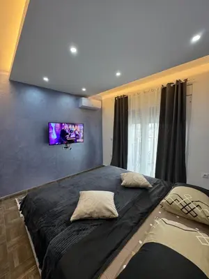 a bedroom with a large bed with a tv on the wall at Stan Pinjes - Ulcinj in Ulcinj