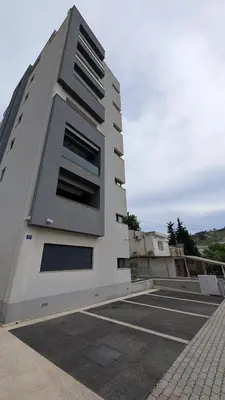 a tall white building with a parking lot at Sutomore - Lux apartment 1 in Sutomore