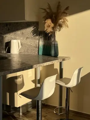 a kitchen with two white chairs and a counter at The best sea view in Prijevor