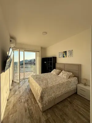 a bedroom with a large bed and a balcony at The best sea view in Prijevor