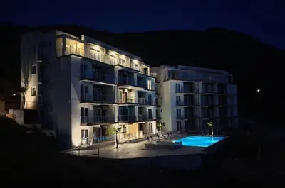 a large apartment building with a swimming pool at night at The best sea view in Prijevor