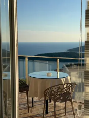 a table and chairs on a balcony with a view of the ocean at The best sea view in Prijevor