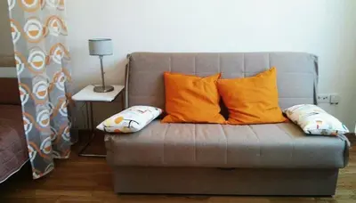 a couch with two pillows on it with a lamp at Nataliia Twister Apartment in Budva