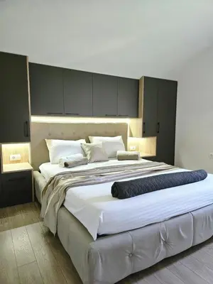 a large bed with white sheets and pillows on it at V&L Apartman in Kravlja
