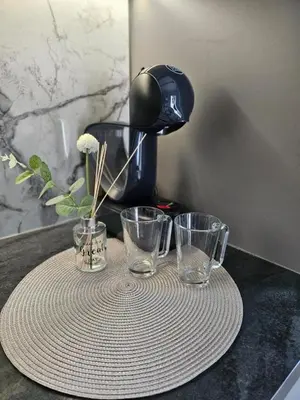 a table with two glasses and a coffee maker at V&L Apartman in Kravlja