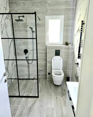 a bathroom with a toilet and a glass shower at V&L Apartman in Kravlja