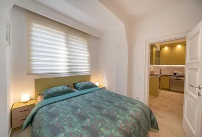 a bedroom with a large bed and a kitchen at Martin di Cattaro-Cosy Retreat Steps from Old Town in Kotor