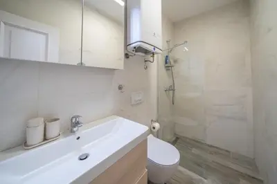 a white bathroom with a sink and a toilet at Martin di Cattaro-Cosy Retreat Steps from Old Town in Kotor