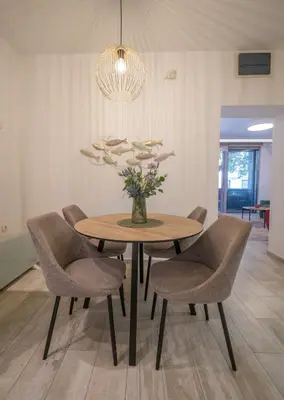 a dining room table with chairs and a vase of flowers at Martin di Cattaro-Cosy Retreat Steps from Old Town in Kotor