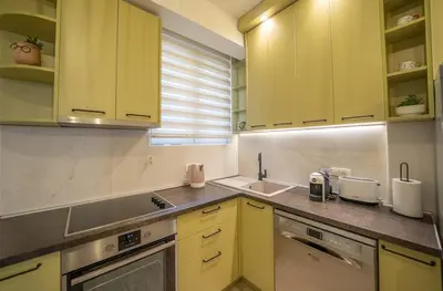 a kitchen with yellow cabinets and a sink at Martin di Cattaro-Cosy Retreat Steps from Old Town in Kotor
