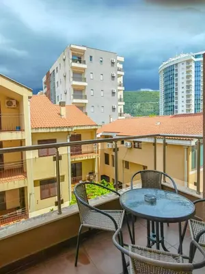 a patio with a table and chairs on a balcony at Seaside Nest Budva -Cozy Retreat 3 min from Beach in Budva