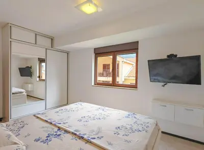 a bedroom with a bed and a tv on the wall at Seaside Nest Budva -Cozy Retreat 3 min from Beach in Budva