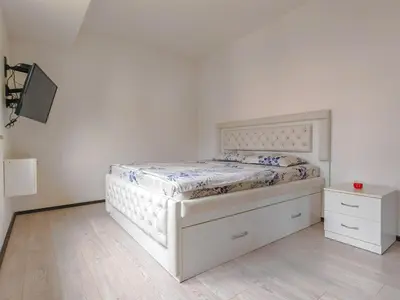 a white bed in a bedroom with a white wall at Seaside Nest Budva -Cozy Retreat 3 min from Beach in Budva