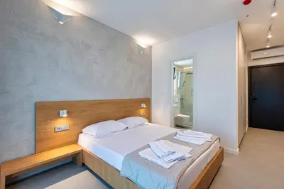 a bedroom with a bed with towels on it at Lucciola Boutique Rooms in Budva