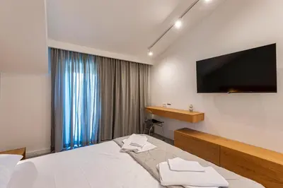 a hotel room with a bed and a flat screen tv at Lucciola Boutique Rooms in Budva