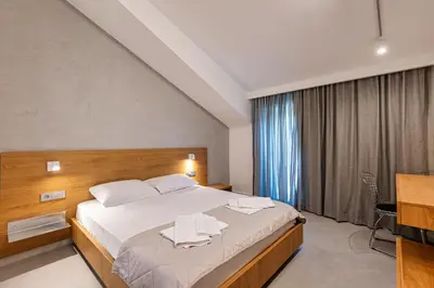 a bedroom with a bed with white towels on it at Lucciola Boutique Rooms in Budva