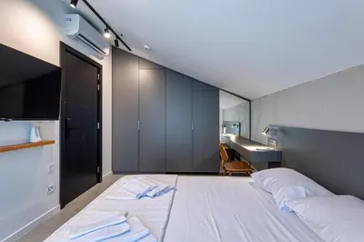 a bedroom with a large white bed and a desk at Lucciola Boutique Rooms in Budva
