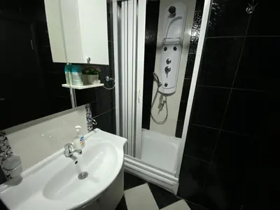a bathroom with a sink and a shower with a shower at Dragan Apartment in Budva