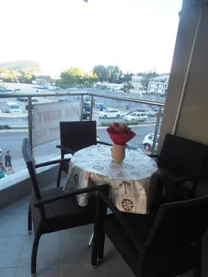 a table and chairs on a balcony with a view of a parking lot at Dragan Apartment in Budva