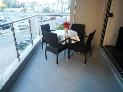 a table and chairs on a balcony with a view of a street at Dragan Apartment in Budva