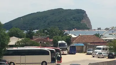 a group of buses parked in a parking lot with a mountain at Dragan Apartment in Budva