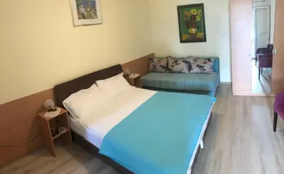 a small bedroom with a bed and a couch at Apartments Sveti Stefan MNE in Sveti Stefan