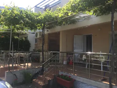 a balcony of a house with a table and chairs at Apartments Sveti Stefan MNE in Sveti Stefan