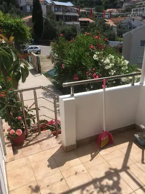 a balcony with flowers and plants on a building at Apartments Sveti Stefan MNE in Sveti Stefan