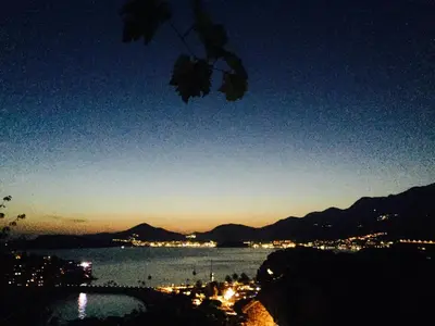 a view of a city and the water at night at Apartments Sveti Stefan MNE in Sveti Stefan