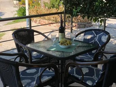 a table with a bottle of wine and a bowl of fruit at Apartments Sveti Stefan MNE in Sveti Stefan