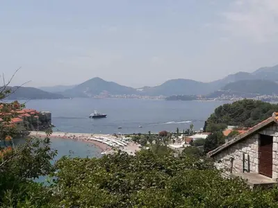 a view of a beach with a boat in the water at Apartments Sveti Stefan MNE in Sveti Stefan