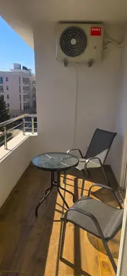 a table and chairs on a balcony with a fan at Apartmani Banović 3 - Ulcinj, Velika plaža in Ulcinj