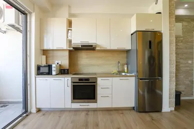 a kitchen with white cabinets and a stainless steel refrigerator at Apartmani Stefan in Bar