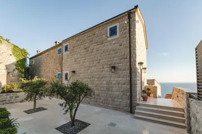 a brick building with two trees in front of it at Villa Boscovich in Katun